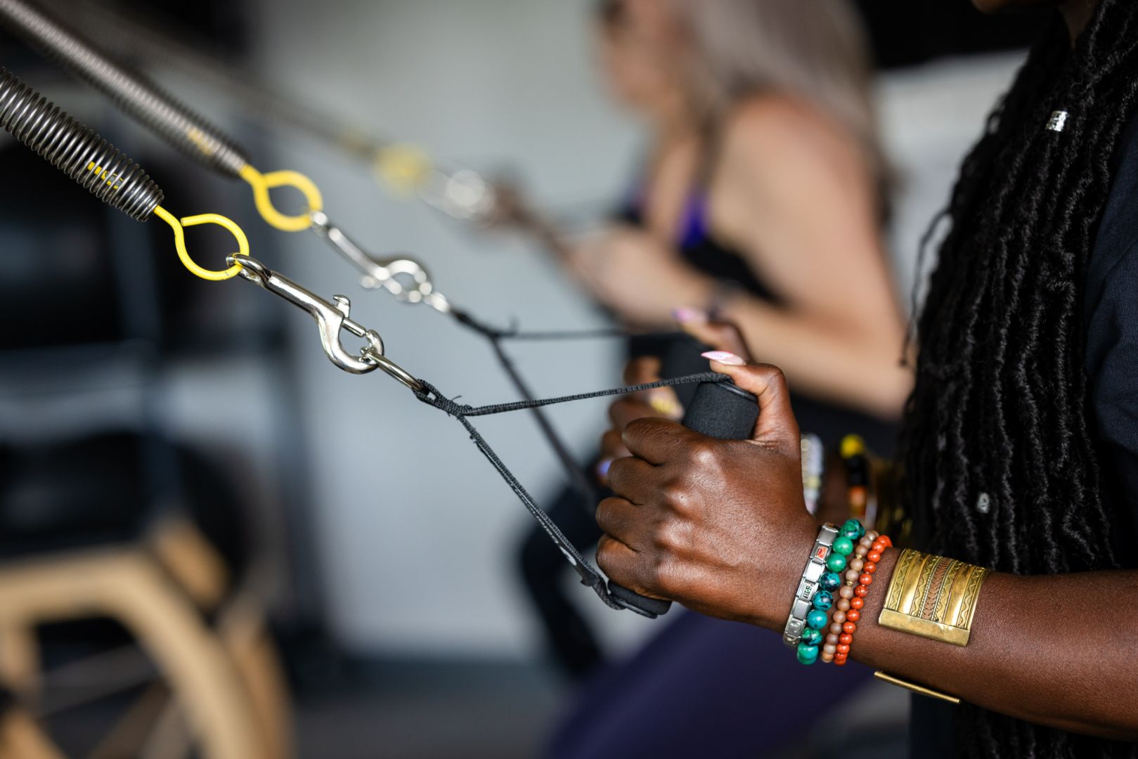 Woman using cable resistance machine handles at gym